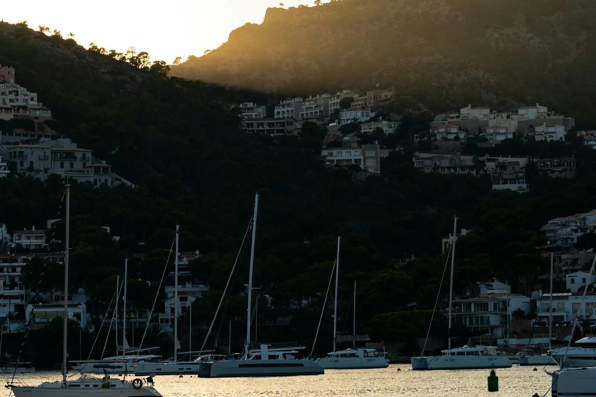 Port d'Andratx harbour at golden hour, boats on the water and the hillside behind